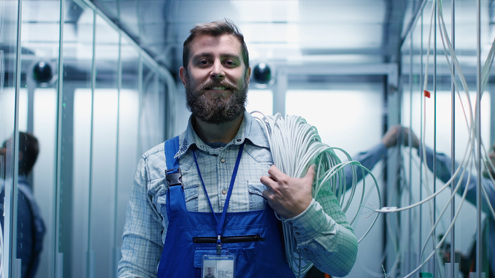 Electrician with cable over his shoulder looking into the camera