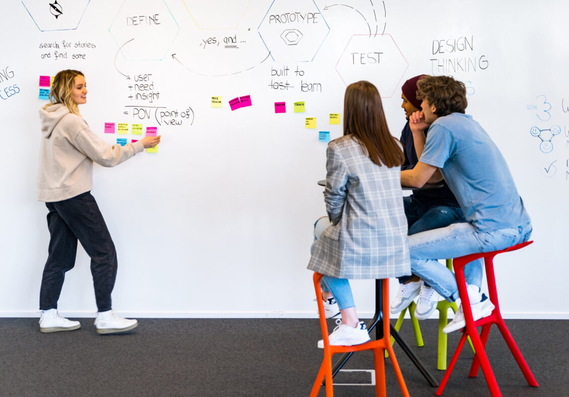 Eine Jugendliche erklärt ihren Mitschülern einen Designprozess