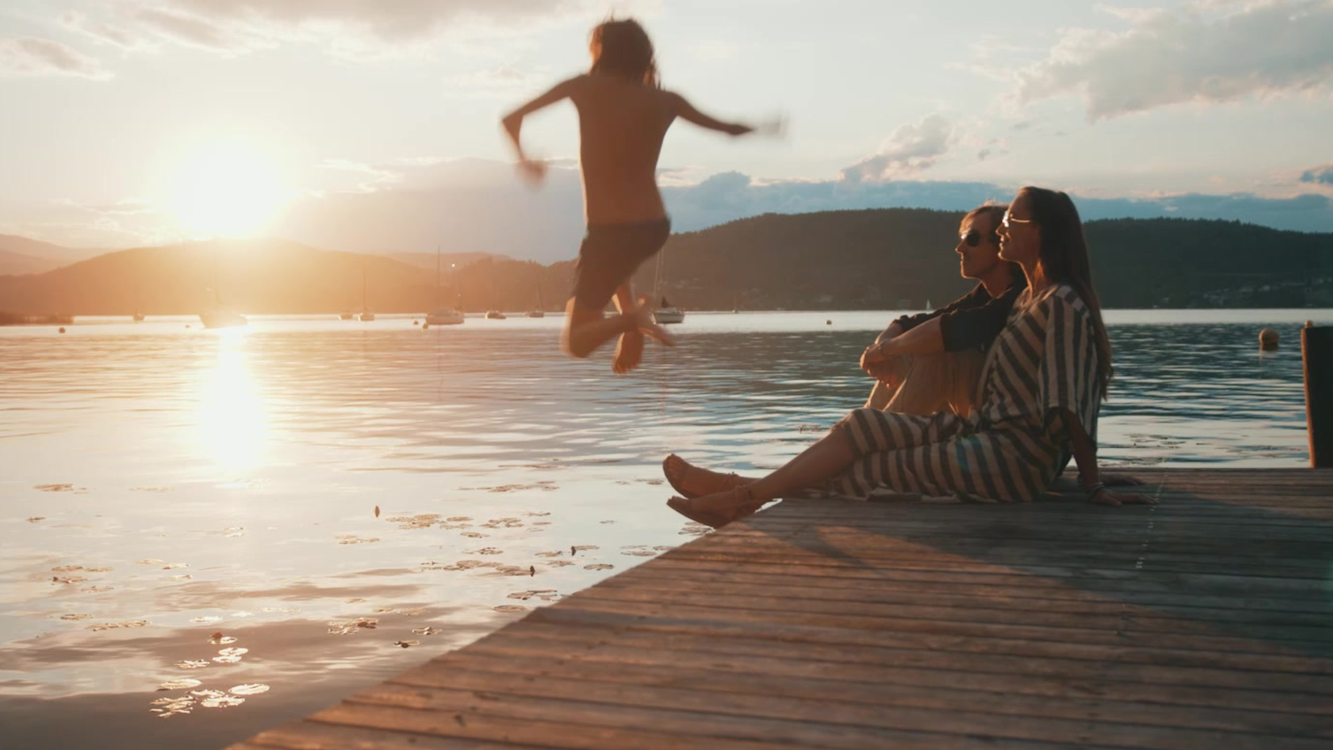 Child enjoying the sunset on Lake Wörth with parents